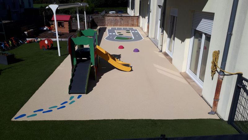 Création d’une piste cyclable pour enfants en sol coulé – aire de jeu sécurisée et durable pour apprentissage du vélo